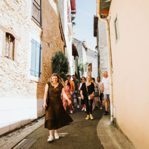 Groupe de personnes souriantes marchant dans la rue.